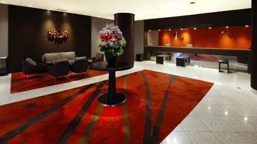 - un hall avec une table et un vase de fleurs dans l'établissement ANA Crowne Plaza Niigata, an IHG Hotel, à Niigata