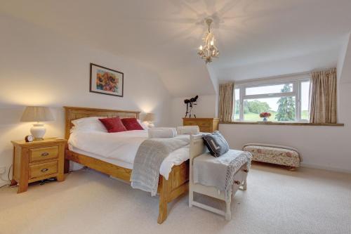 a bedroom with a large bed and a window at Flint Cottage in Stiffkey