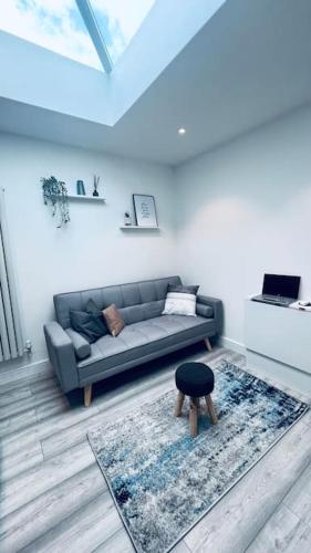 uma sala de estar com um sofá e um banco em Contemporary studio apartment em Pemberton