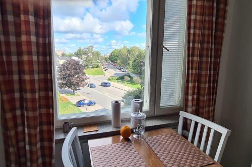 a table and chairs in front of a large window at Renovated handy spacious 3 room apartment for tourists, workers and students in Rauma