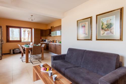 ein Wohnzimmer mit einem Sofa und einem Tisch in der Unterkunft Harbour Views Gozitan Villa Shared Pool - Happy Rentals in Mġarr