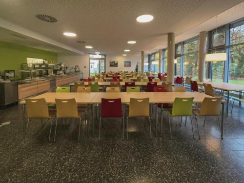 a cafeteria with a large table and chairs at Jugendherberge Braunschweig in Braunschweig