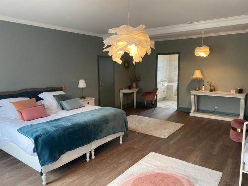 um quarto com uma cama grande e um lustre em La Villa Champagne Ployez-Jacquemart em Ludes