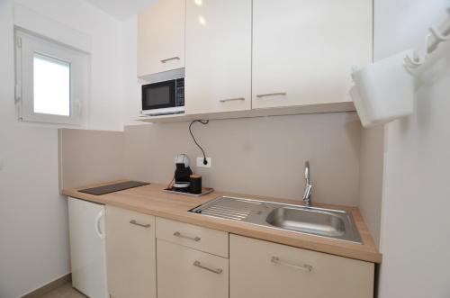 a small kitchen with a sink and a microwave at M&N Apartment in Rovinj