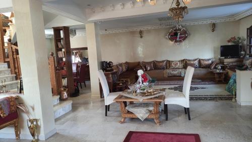 sala de estar con sofá, mesa y sillas en Happy Life (All inclusive Program), en Ifrane