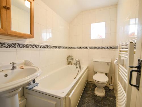 a bathroom with a tub and a toilet and a sink at The Lymings in Lyme Regis