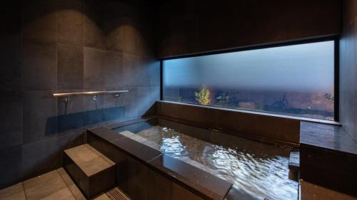 a bathroom with a fish tank and a window at Onn Yuda Onsen in Yamaguchi