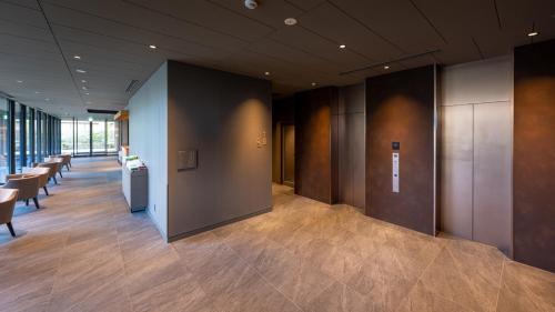 a lobby with a row of tables and chairs at Onn Yuda Onsen in Yamaguchi