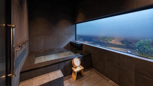 a toilet in a bathroom with a large window at Onn Yuda Onsen in Yamaguchi