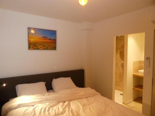 une chambre avec un lit avec un tableau sur le mur dans l'établissement Les Papillons du Ventoux - Le Souci - éénslaapkamerappartement met terras en tuin, à Malaucène