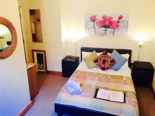 a bedroom with a bed with pillows and a mirror at Bridge View Guest House in Ironbridge