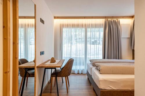 een hotelkamer met 2 bedden en een tafel en stoelen bij Les Ciases Chalets Dolomites Apt 2 in San Vigilio Di Marebbe