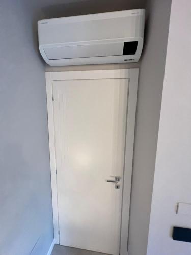 a room with a ceiling heater and a white door at Casa Zovetto in Cuneo