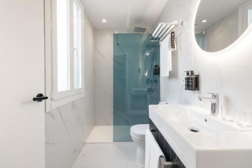a bathroom with a shower and a toilet and a sink at Ikonik Gran Vía in Madrid