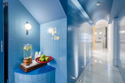 a blue tiled hallway with a bowl of fruit on a shelf at Ikonik Gran Vía in Madrid