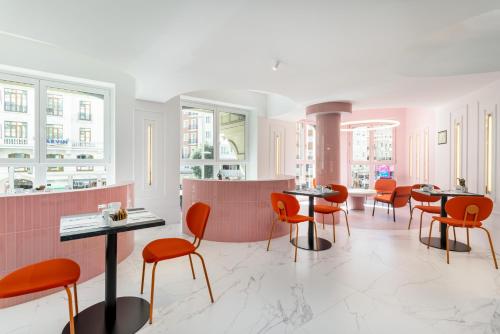 a restaurant with orange chairs and tables in a room at Ikonik Gran Vía in Madrid