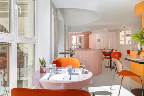 a restaurant with orange chairs and a table at Ikonik Gran Vía in Madrid
