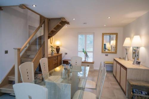 a dining room with a glass table and white chairs at The Muse at Framlingham Sleeps 4 in Framlingham