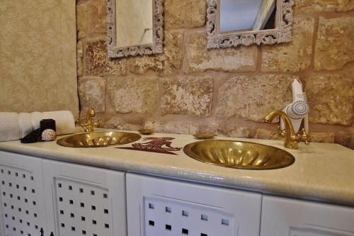 a bathroom with two sinks and two mirrors at Chapel 5 Boutique Suites B&B in Naxxar