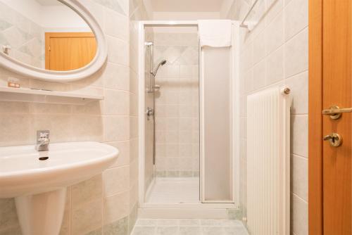 a white bathroom with a sink and a shower at Appartamenti Gabry in Riva del Garda