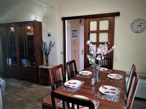 einen Esstisch mit Stühlen und einen Holztisch mit Blumen in der Unterkunft sapfo's house in Ágios Ioánnis