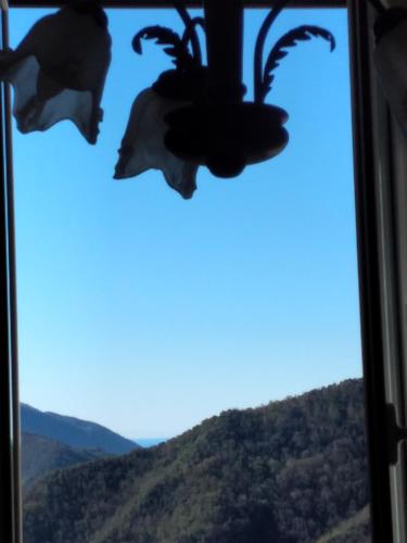 a window with a view of a mountain at CasarinoLaurino Among Cinque Terre Genova And Portofino in Uscio