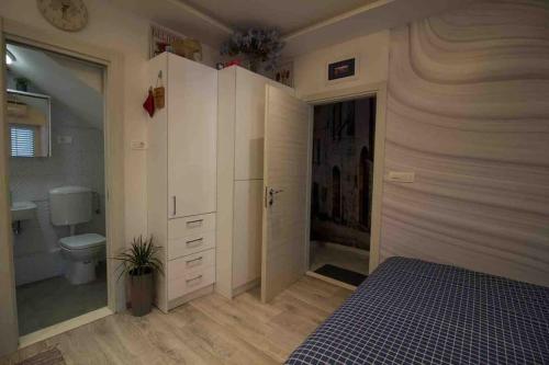a bedroom with a bed and a bathroom at Mitella studio apartman in Solin