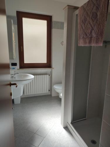 a bathroom with a sink and a toilet and a window at Agriturismo L'Uliveto in Gargnano