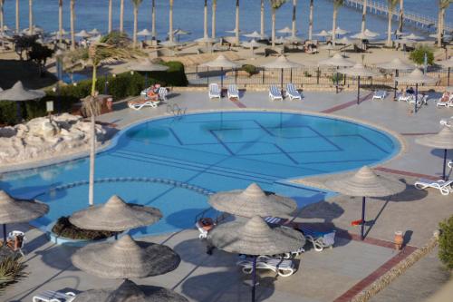 an overhead view of a pool with umbrellas and the ocean at Blend Elphistone Resort Marsa Alam in Abu Dabab