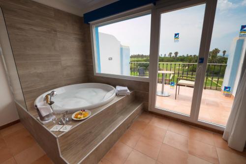 a bathroom with a tub and a large window at Playaballena in Costa Ballena