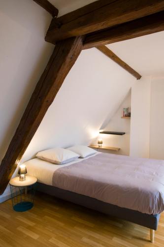 - une chambre mansardée avec un grand lit dans l'établissement La couronne Maison 80m2 garage & terrasse, à Sainte-Croix-en-Plaine