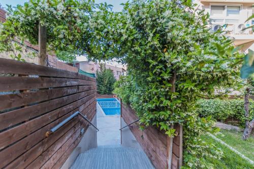 a garden with a wooden fence and an orange tree at Porto Planos Beach Hotel in Tsilivi