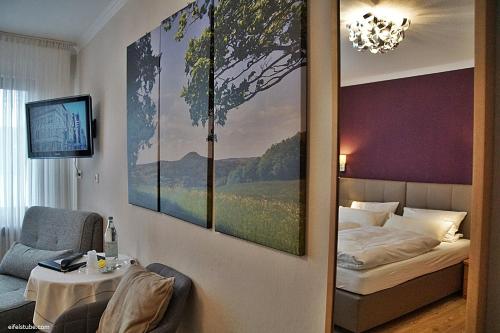 een slaapkamer met een bed en een schilderij aan de muur bij Hotel Eifelstube in Rodder