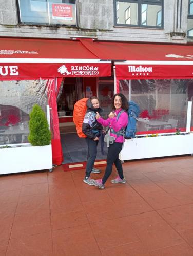 two people standing in front of a store at Albergue Rincón del Peregrino Porriño-Pleno centro-City Center in Porriño