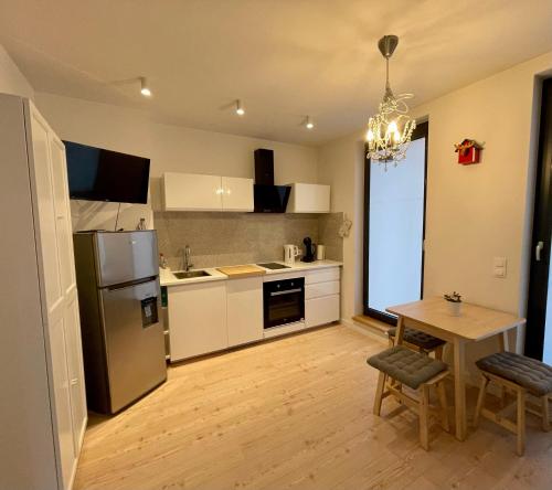 a kitchen with white cabinets and a table and a refrigerator at Niezapominajek in Opole