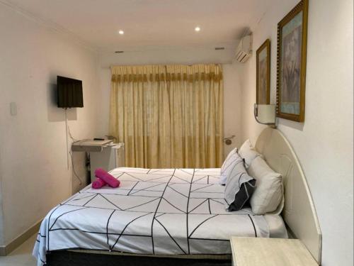 una camera da letto con un letto bianco con un oggetto rosa sopra di Bogotá a Pietermaritzburg