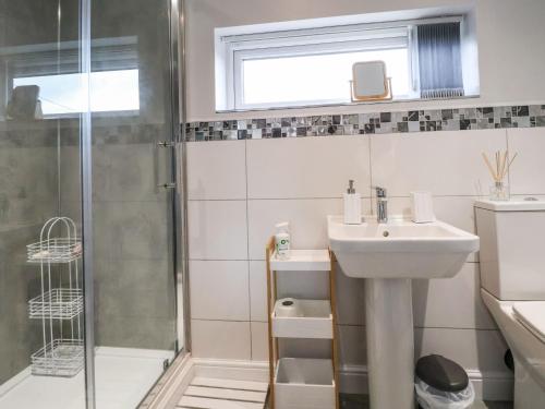 uma casa de banho com um lavatório e um chuveiro em Meols Holiday Lodge em Wirral