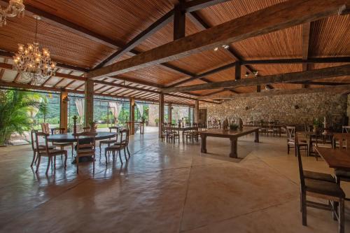 une salle à manger avec des plafonds en bois, des tables et des chaises dans l'établissement Pousada Brisa da Serra, à Tiradentes