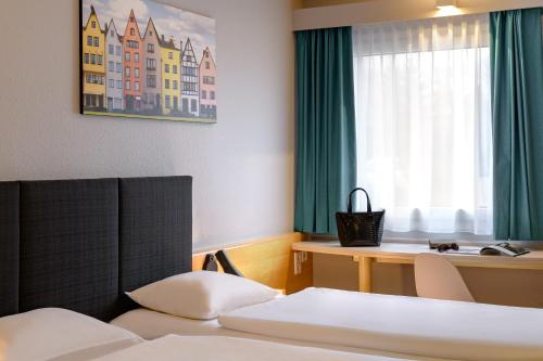 Habitación de hotel con cama y escritorio en ibis Köln Frechen, en Colonia
