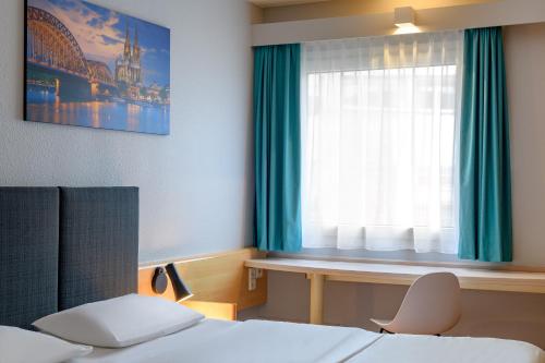 a hotel room with a bed and a window at ibis Köln Frechen in Cologne