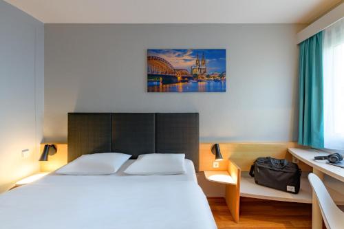 a bedroom with a white bed and a bridge at ibis Köln Frechen in Cologne