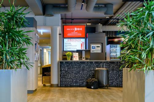 a lobby with two potted plants and a counter at ibis Köln Frechen in Cologne