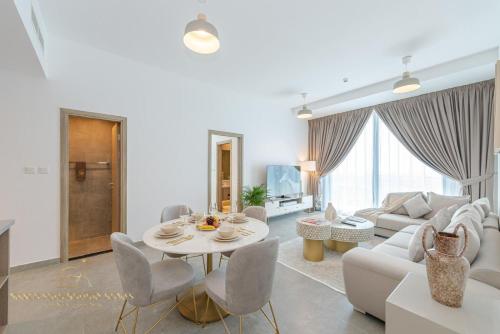 een woonkamer met een tafel en een bank bij Marco Polo - Stunning 2 BR With Marina Views, Huge Pool & Gym in Dubai