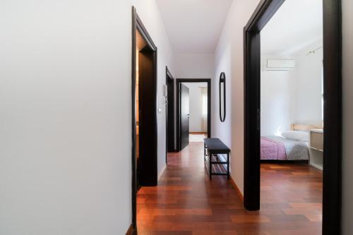 a hallway leading to a bedroom with a bed and a mirror at Ladybug in Dobrota