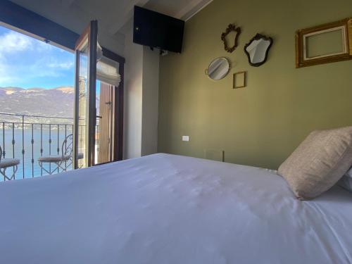sypialnia z dużym łóżkiem i balkonem w obiekcie Il Molo Di Hotel Villa Aurora w mieście Lezzeno