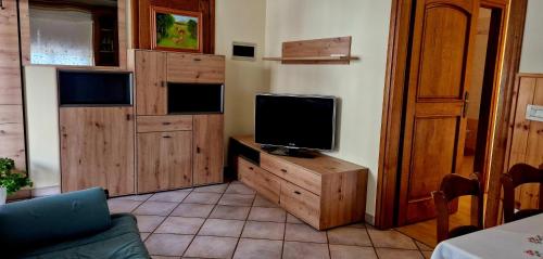 una sala de estar con TV en un tocador de madera en Apartma Arkade en Črniče