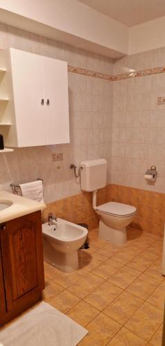 y baño con aseo, bidet y lavamanos. en Apartma Arkade en Črniče