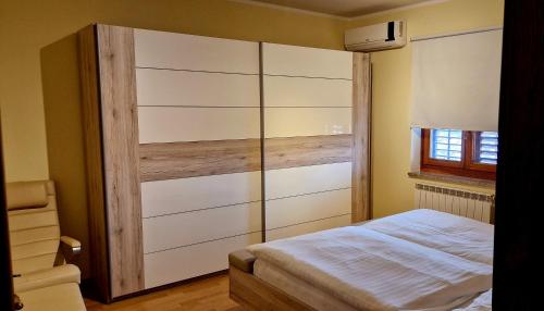 een slaapkamer met een bed en een grote kast bij Apartma Arkade in Črniče