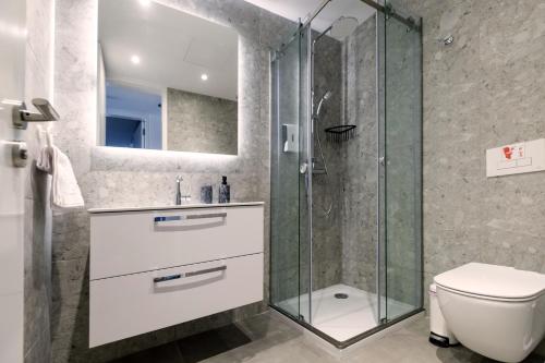 a bathroom with a glass shower and a toilet at Gaia Seaview Apartment 1 in Larnaka