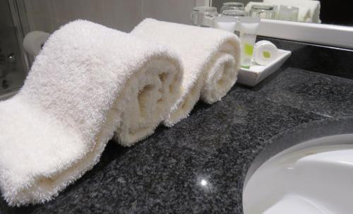 a bathroom with a sink and towels on a counter at Pestana Rovuma in Maputo